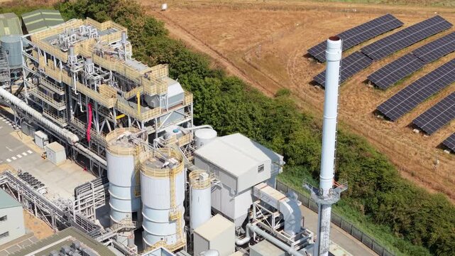 Close up aerial view of biomass power station chimney stack and industrial metal roof in UK