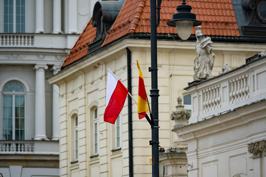 Polish Flag and Warsaw City Flag Waving in Front of Historical Neoclassical Architecture