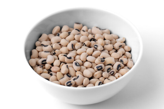 Raw dry black eyed peas beans in a white ceramic bowl isolated on white