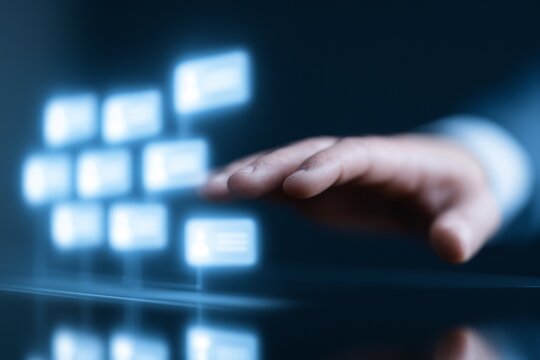 Human hand reaching towards virtual interface with glowing profiles for digital networking and talent management