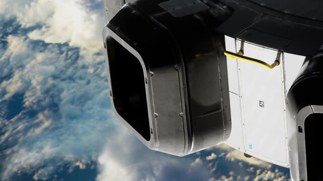 A close up view of a spacecraft part is seen against the backdrop of Earth from space. The image shows the texture and design of the spacecraft while clouds are visible below.