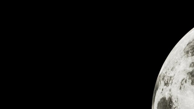 The full moon is visible in the night sky. Its bright light illuminates the dark surroundings. The surface details of the moon are clear and distinct.