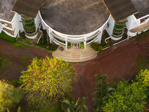Aerial view of a modern lodge with a curved facade and lush surrounding gardens in Santa Cruz, Galapagos Province, Ecuador.