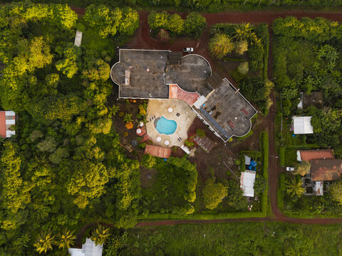 Aerial view of a building with a swimming pool surrounded by lush tropical trees and vegetation Santa Cruz, Galapagos Province, Ecuador.