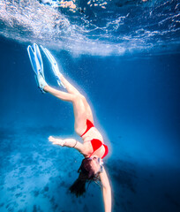 Snorkeler swimming above a textured rocky seabed in deep blue clear water, viewed from above, with large negative space for travel advertising, vacation and marine themes. © JairoMZ