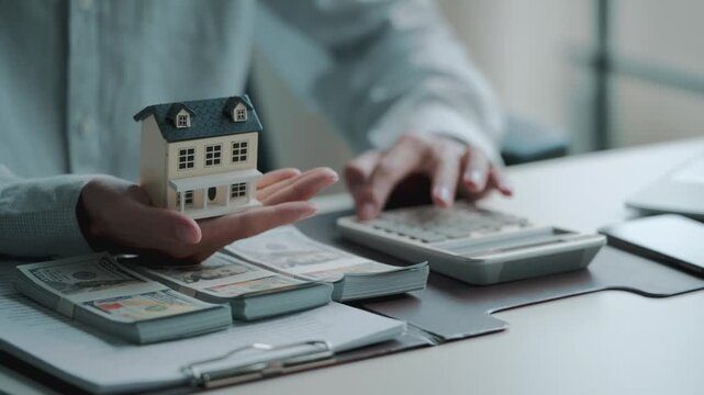 banker calculates mortgage and property valuation for home loan in office