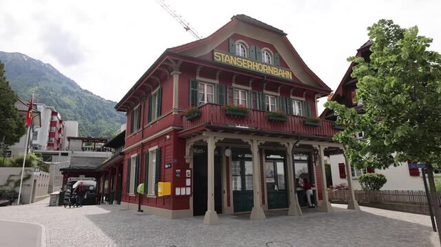 Stans, Nidwalden, Switzerland - 22 August 2026: View of the historic Stanserhorn-Bahn station building with its red facade and wooden architecture in the town center.