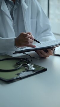 doctor updates medical record documents in a hospital consultation room