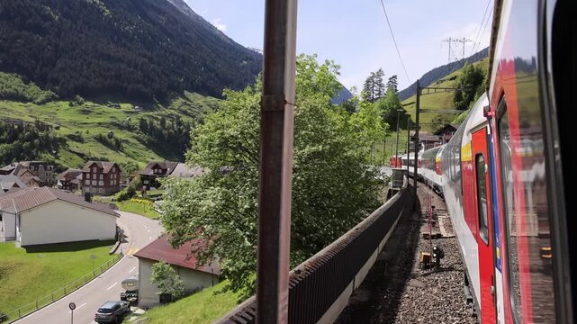 Lugano, Switzerland - 21 August 2026: View of the Gotthard Panorama Express train traveling through the scenic mountainous landscape of the Swiss Alps.