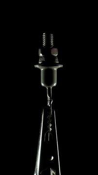Metal power diode electronic component with threaded stud and electrical terminal against dark background.