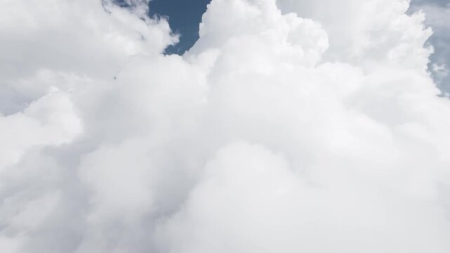 Camera moving forward through white clouds into blue sky