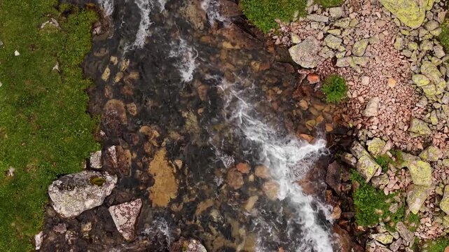 Aerial view of rapid mountain stream flowing over rocks