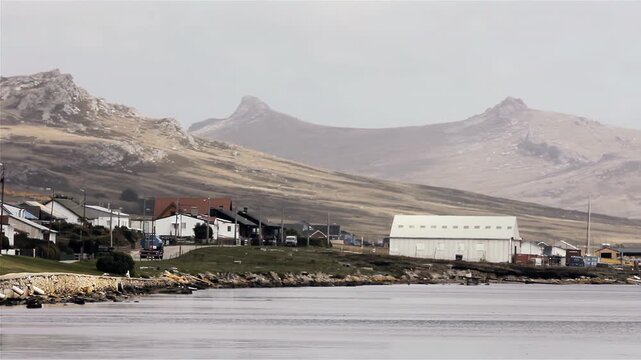 Truck Driving On Coastal Road With Two Sisters Mountains In Backdrop In Port Stanley, Falklands (Islas Malvinas) - 4K