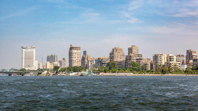 Panoramic view along the banks of the Nile, with the city of Cairo high-rise apartment buildings and minarets. Cairo is the capital and largest city in Egypt.