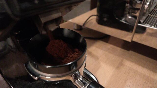 Grinding coffee into portafilter.