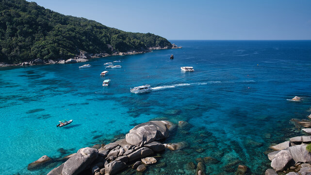 Turquoise gradient water and granite boulders with tour boats anchored at Donald Duck Bay, Similan Islands, Thailand