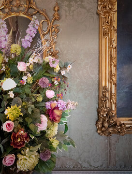 Large Floral Arrangement By An Ornate Gold Picture Frame In An English Country House In Berkshire