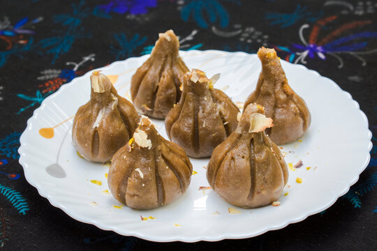 Brown chocolate modak on white plate