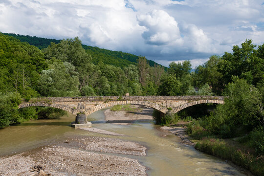 Ancient stone bridge on the Dakh river on a July afternoon. Dakhovskaya, Republic of Adygea. Russian Federation