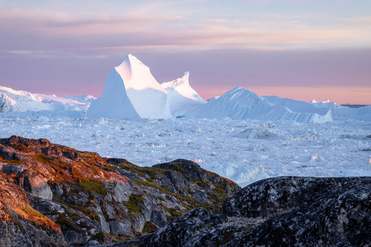 Giant iceberg in Greenland from a hiking path at sunset