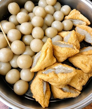 Steaming hot Indonesian street food snacks cilok and stuffed tofu bakso aci in metal steamer pot