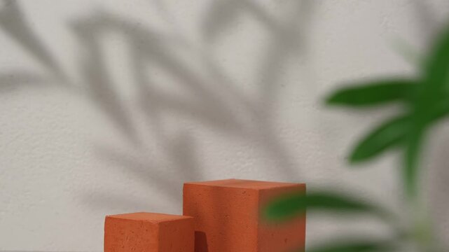 Cosmetic product presentation scene made with terracotta textured cube podium with a leaf shadow motion