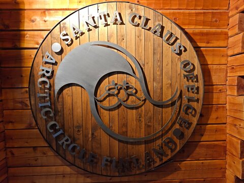 Rovaniemi, Finland-Dec.3rd 2025: close-up official logo of the Santa Claus Office mounted on a log wall 
