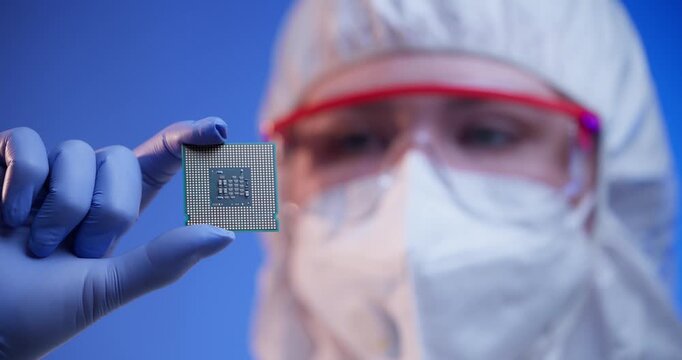 Laboratory technician holding microchip in cleanroom environment, concept control quality of semiconductor on lab of artificial intelligence factory.