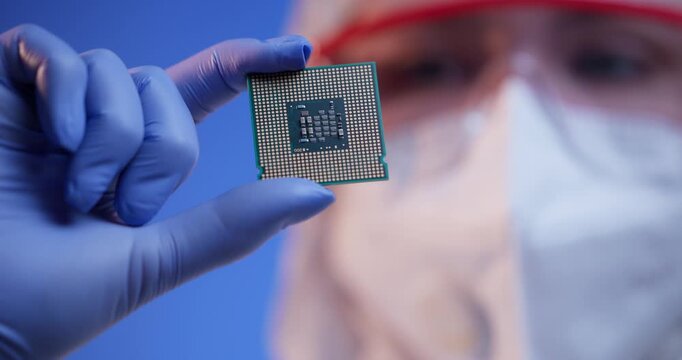 Closeup technician holding microchip in controlled lab environment, concept control quality of semiconductor.