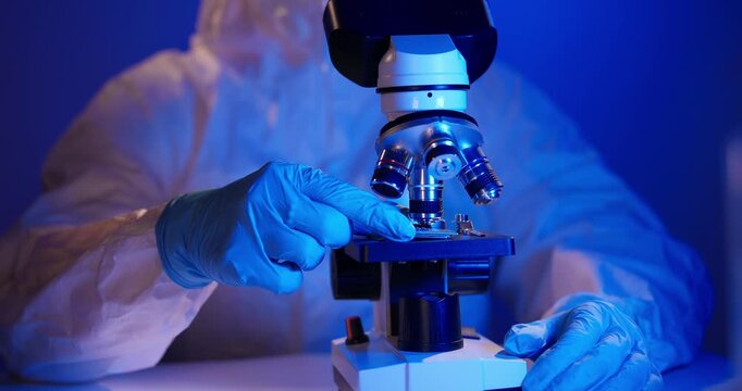 Lab technician holding AI cpu chip by microscope for control quality in laboratory artificial intelligence data center.
