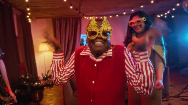 Portrait of African American young woman dancing with multiethnic friends at festive holiday party in slow motion. Ideal for Christmas advertising and seasonal event promotions
