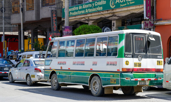 Huancayo, Per&uacute;, Peru : A public minibus travels through a busy commercial street. Taxis, shops and overhead wires frame daily transport in the Peruvian Andes.