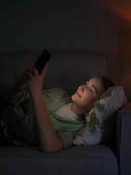 Relaxed woman using smartphone on couch
