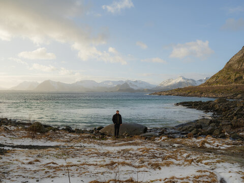 Man standing on a beach on Lofoten islands in winter 