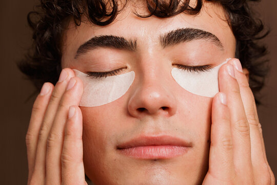 Man Applying Under-Eye Patches While Relaxing Indoors