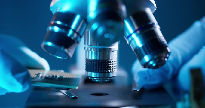 Laboratory artificial intelligence data center, Gloved hands use microscope for control quality of microprocessor semiconductor.
