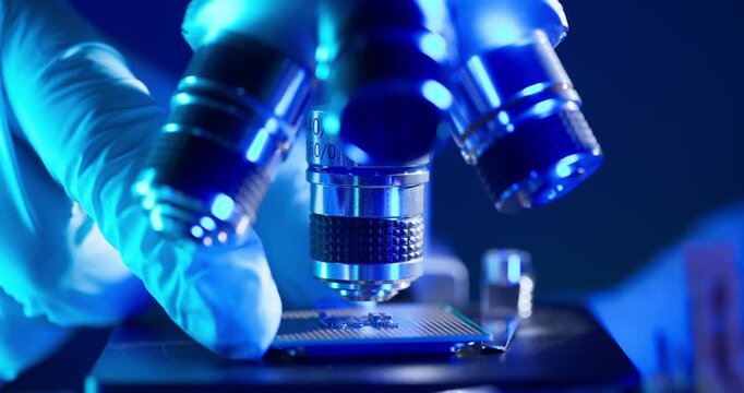 Lab technician holding AI cpu chip by microscope for control quality in laboratory artificial intelligence data center.
