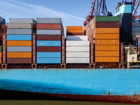 Aerial view of a large container ship loaded with colorful shipping containers docked at the port in Hamburg, Hamburg, Germany.