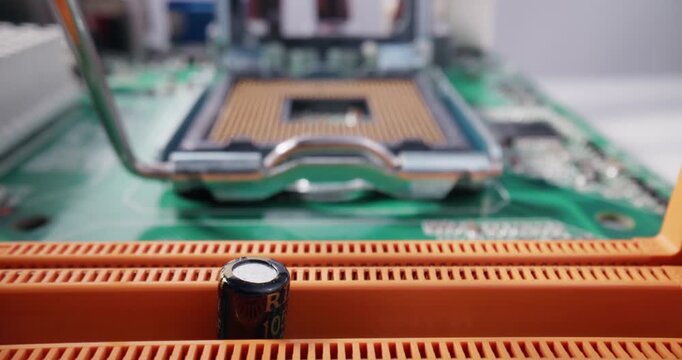 Slow motion insertion of cpu chip into motherboard socket on green pcb at electronics workbench with gloved hands, macro probe tracking shot.