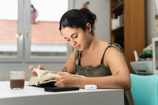 Young Woman Reading a Book at Home During the Day