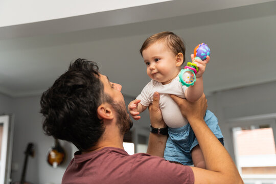 Father Holding Baby in Living Room at Home