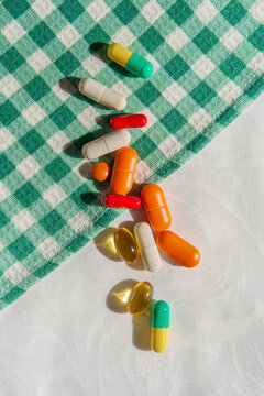 Colorful Vitamins and Dietary Supplements on Green Gingham Tablecloth