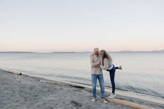 Older couple sharing a candid kiss on a calm beach
