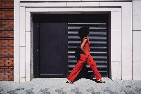 Woman walk past modern architecture in urban setting