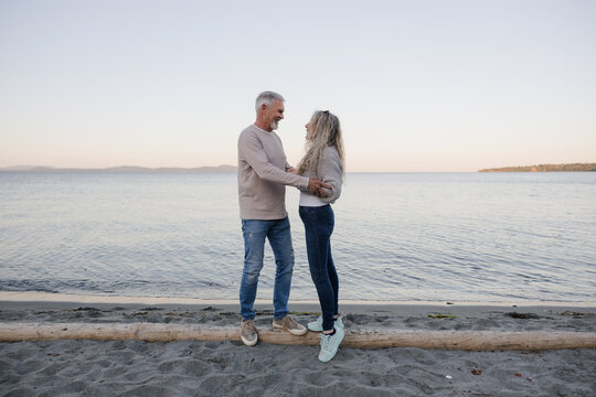 Candid senior couple sharing a tender moment on a calm beach
