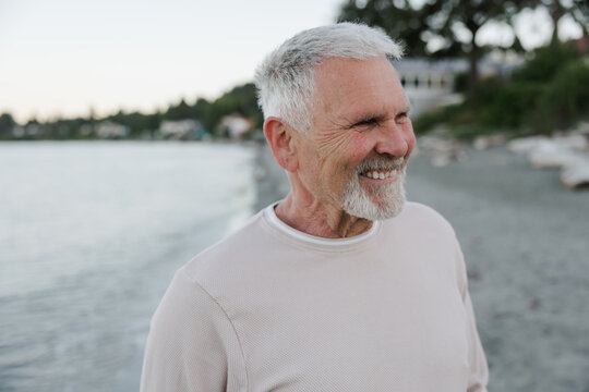 Candid portrait of a happy senior man smiling on a beach