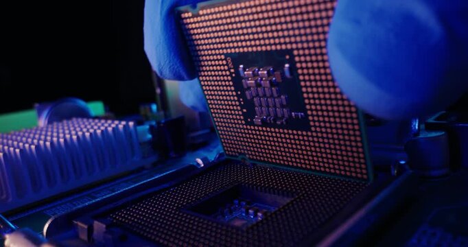 Slow motion probe macro of cpu being inserted into motherboard socket inside illuminated computer case, data center neon light.