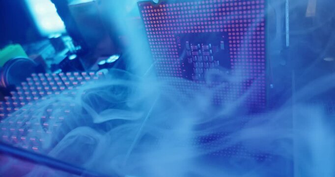 Fire and overheating with smoke of cpu processor and socket on motherboard in electronics lab under blue metallic lighting, probe macro view.