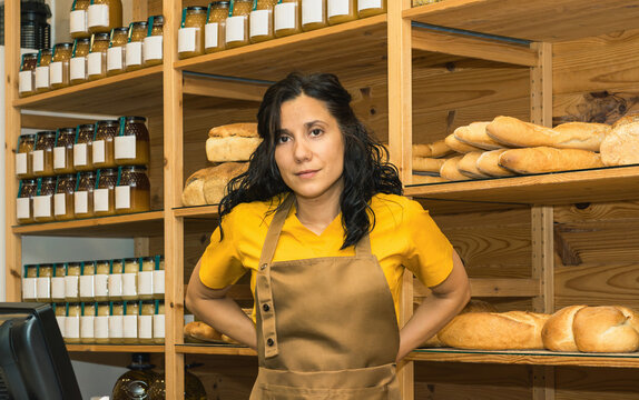 Woman baker shop owner smiling standing in bakery