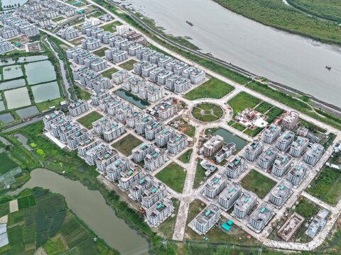Aerial view of the Khurushkul Ashrayan Prokolpo housing project with rows of modern apartment buildings, green spaces, and a circular plaza in Cox's Bazar, Chittagong Division, Bangladesh.